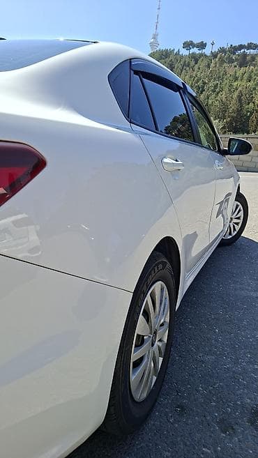 Kia: Kia Rio sedan – ağ rəng, Azərbaycan nömrə nişanı ilə. Şəhər və uzun — 5