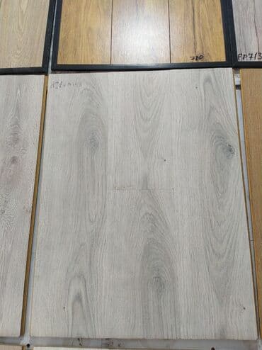 Açıq boz rəngdə laminat döşəmə paneli. Bu panel, ev və ya ofis