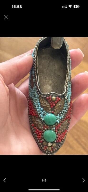 sirqa gulu haqqinda: Bu, rəngli muncuqlu bəzəkləri və iki yaşıl daş detalı ilə bəzədilmiş — 1