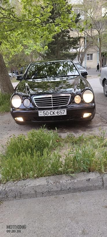 Mercedes-Benz E-Class (W210) sedan – qara rəng, klassik iki dairəvi