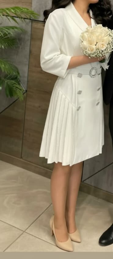 Ağ rəngli, dizə qədər uzunluqda şıq qadın paltarı. Yuxarı hissəsi