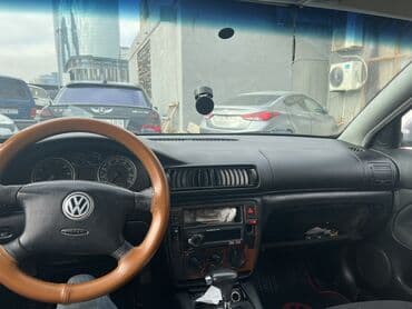 Volkswagen sedan – gümüşü rəng, qara radiator barmaqlığı və VW loqolu