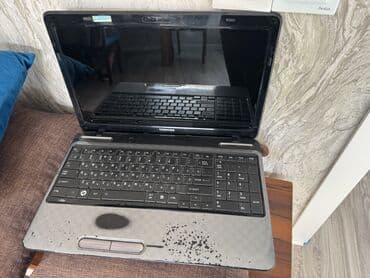 notebook çanta: Toshiba markalı boz rəngli noutbuk. Cihazın üst qapağında Toshiba — 2