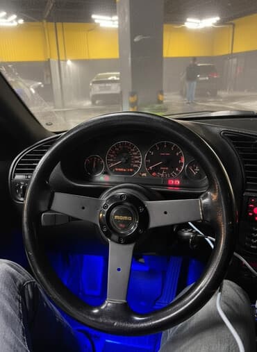 MOMO sükan — idman üslublu, üçşüalı, qara rəngdə, mərkəzdə “MOMO”