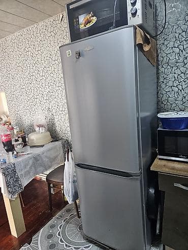 Gümüş rəngli iki qapılı soyuducu - Yuxarıda soyuducu bölmə, aşağıda