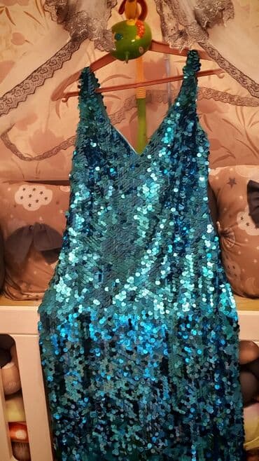 Mavi və firuzəyi rənglərdə parıldayan pulcuqlarla bəzədilmiş qadın