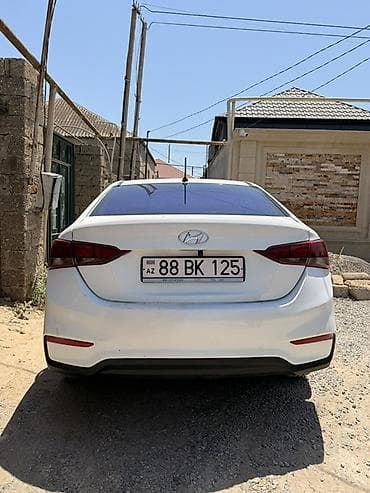Hyundai Accent sedan – ağ rəng, benzinli, ön çəkişli. Kompakt ölçülü — 4