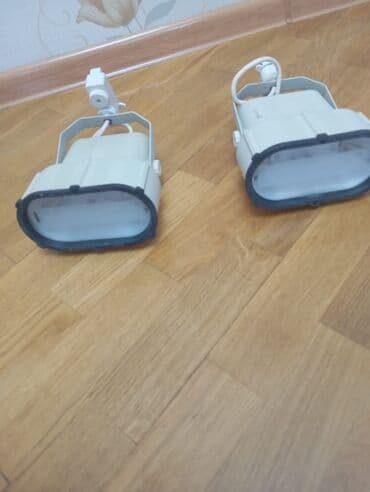 İki ədəd ağ rəngli proyektor lampası. Bu lampalar müxtəlif məkanlarda