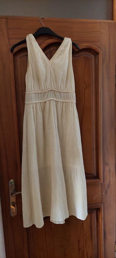 Bej rəngdə, V yaxalı qadın maksi donu. Bu donun beli büzməli dizayna