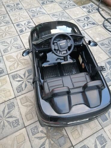 ucuz uşaq maşınları: Uşaqlar üçün nəzərdə tutulmuş qara rəngli elektrikli maşın. Bu model — 4