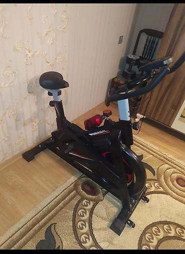 Qara rəngli, idman zalı üçün nəzərdə tutulmuş velosiped. Üzərində su