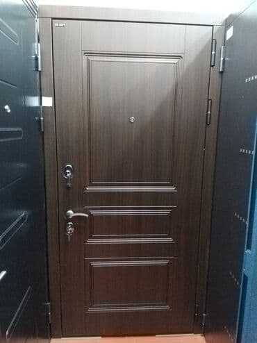 serf qapılar: Qəhvəyi rəngdə, taxta panellərlə bəzədilmiş, möhkəm metal qapı. Qapıda — 2