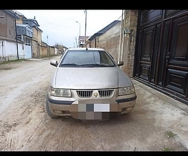 saipa 132 se: Açıq qəhvəyi rəngdə sedan tipli avtomobil. Avtomobilin ön hissəsində — 1