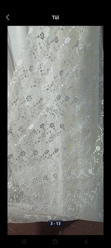 Zərif güllü naxışları olan ağ tül pərdə. Yüngül və şəffaf materialı