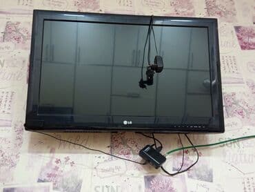 lg azerbaijan: Divara quraşdırılmış qara rəngli LG LCD televizor. Televizorun altında — 1