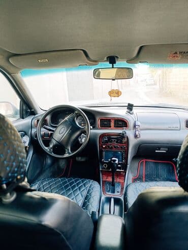 əllə çəkilmiş maşın şəkilləri: Kia Sephia sedan - Kuzov: 4 qapılı sedan, tünd yaşıl rəng - Ön hissə — 8