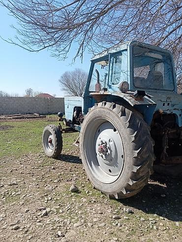 t 28 matoru: Sükanlı kabinli mavi traktor, arxasında kotan/oydaşı (tillər) qoşqusu — 7