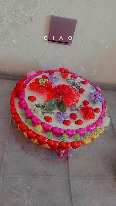 Böyük ölçülü, dairəvi bəzəkli tort. Üzəri ağ krem ilə örtülüb