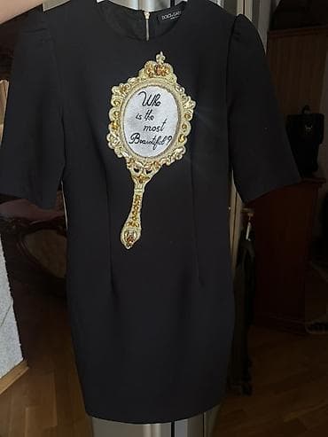 Qara mini paltar, qısa qol, dairəvi yaxa. Ön hissədə iri əl güzgüsü