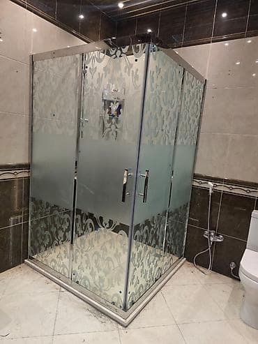 Şəffaf şüşə panelləri və bəzəkli naxışları olan künc duş kabinəsi