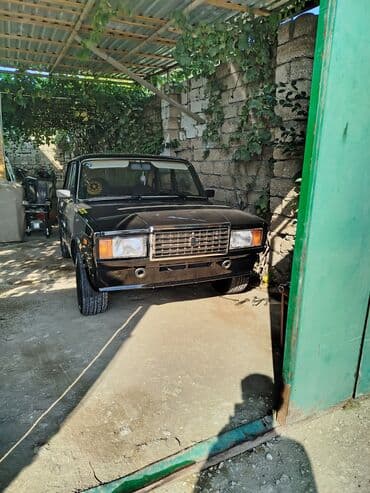 Ön hissəsində iki əlavə HELLA fənəri olan qara rəngli Lada 2107 sedan — 2
