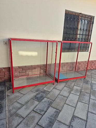 Şüşə yan divarları və qırmızı metal çərçivəsi olan bu vitrin