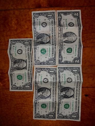 1 manat nece dollar: Salam, 2 dolların üst hissəsində zədə var və arxasında yazı var. 1 — 1