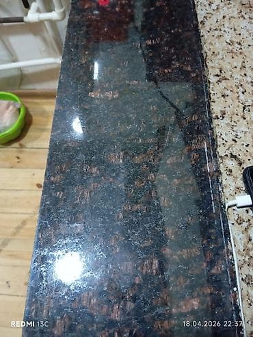 Tünd qəhvəyi və qara çalarlı, xırda ləkəli naxışlı qranit mətbəx