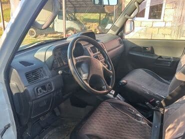 турбо аз трактор: Ağ rəngli, 4 qapılı Mitsubishi Pajero SUV. Avtomobilin arxa hissəsində — 5