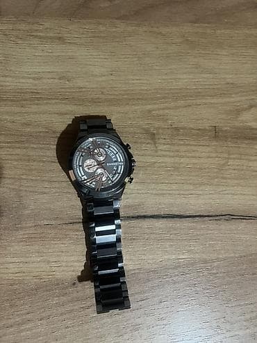 Qara rəngli, metal kəmərli kişi qol saatı. Saatın siferblatı
