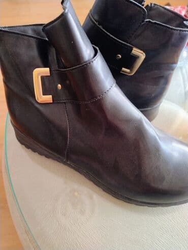 Dəri görünüşlü, qara rəngli qadın qısa çəkmələri. Yan tərəfində qızılı