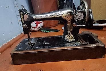 Antik mexaniki tikiş maşını - Korpus: tökmə dəmir, qara lak üzərində