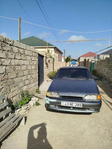 lada qapi: Tünd boz rəngli sedan tipli avtomobil. Arxa tərəfində spoyler — 1
