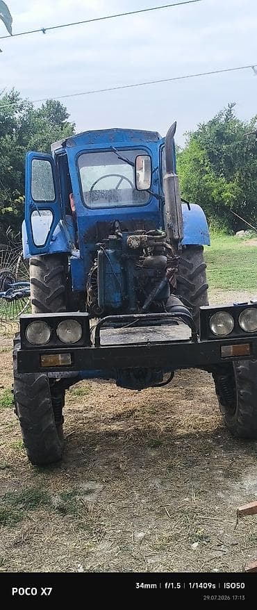 Mavi rəngli təkərli traktor - Kabinli, geniş ön görünüşlü şüşə və yan