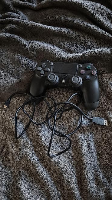 PlayStation üçün qara rəngli oyun pultu təqdim olunur. Şəkildə pultla