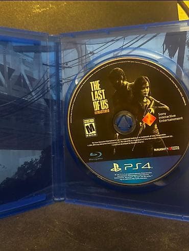 playstatio: PS4 üçün **The Last of Us Remastered** oyun diski. Bu nəşr — 2