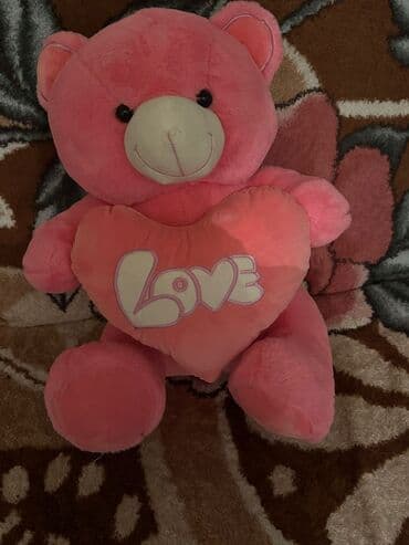 Yumşaq oyuncağ ayı – çəhrayı rəngdə, qucağında ürək formasında yastıq