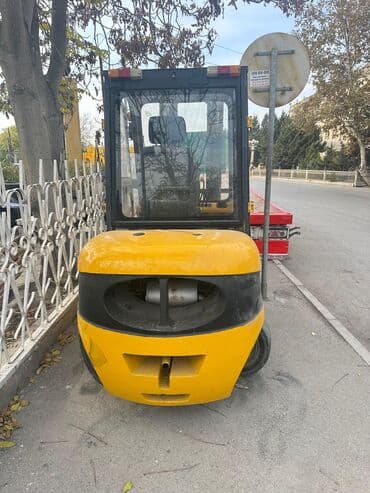 Sarı rəngdə kabinəli yükgötürən (forklift). - Qapalı kabinə: ön, yan