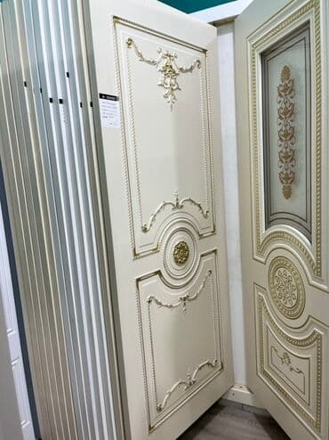 Bej rəngdə, üzərində qızılı naxışlar olan klassik üslubda qapı. Otağa