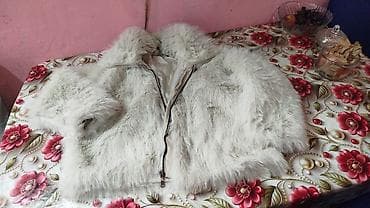 Açıq rəngli, yumşaq tüklü qadın üst geyimi. Model qısa fasonludur və — 1