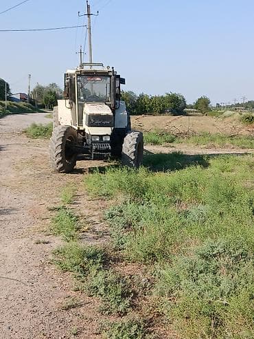 Ağ-qara rəng sxemli təkərli kənd təsərrüfatı traktoru. Kabinəli, geniş