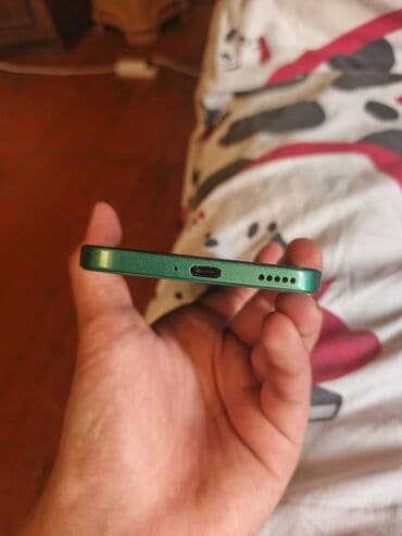 телефон fly evo: Yaşıl rəngdə müasir smartfon. Cihazın ekranında "dinamik ada" — 3