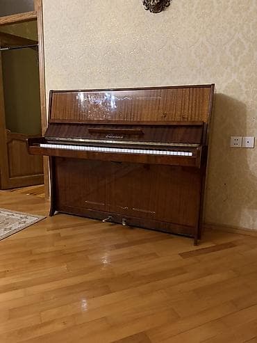 Təzə vəziyyətdə qalmış pianino hazır köklənib üstünün mebelində heç