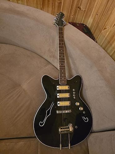 Elektrik gitara – yarı-hollow korpuslu, qara rəngdə, ağ haşiyəli