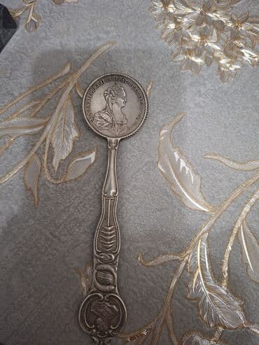 gumuş qaşıqlar: Antik xatirə qaşığı – gümüş tonlu metal, detallı relyef bəzəklərlə. - — 2