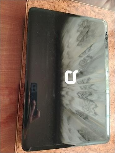 Qara rəngli Compaq notbuk. Üzərindəki klaviatura və toxunma paneli