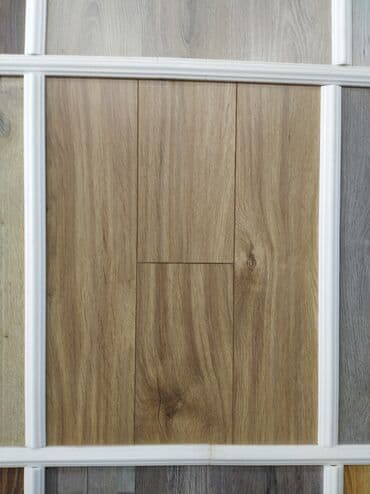 Açıq taxta rəngində laminat döşəmə paneli. Panelin səthi taxta