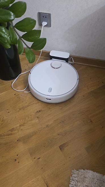 Ağıllı robot tozsoran – ağ rəngdə, dairəvi korpuslu, dok-stansiya