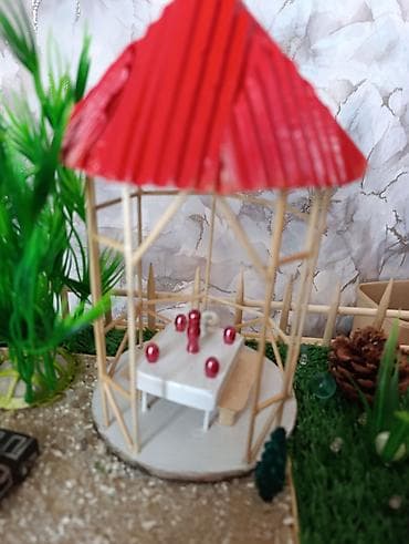 flo memar ecemi: Miniatür ev modeli, qırmızı damı və ətrafında hasarlı yaşıllığı ilə — 7