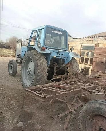 sepli traktor: Sükanlı kabinli mavi traktor, arxasında kotan/oydaşı (tillər) qoşqusu — 2